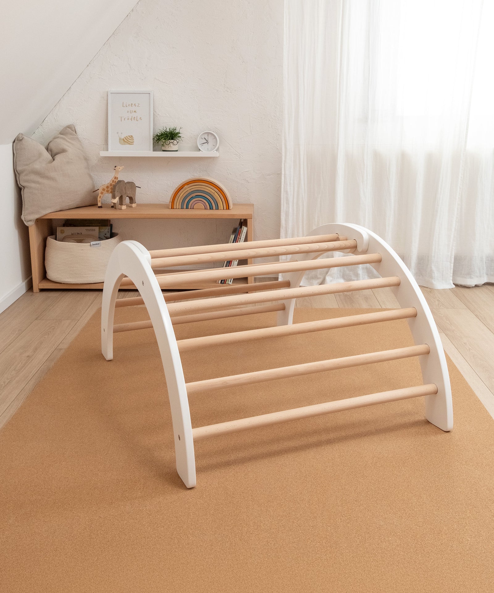 Fördert die Entwicklung*Der Kletterbogen fördert erste Stehversuche sowie die Motorik beim Klettern und schult dabei die Bewegungssicherheit.|Kletterbogen natur-weiß auf Korkmatte.