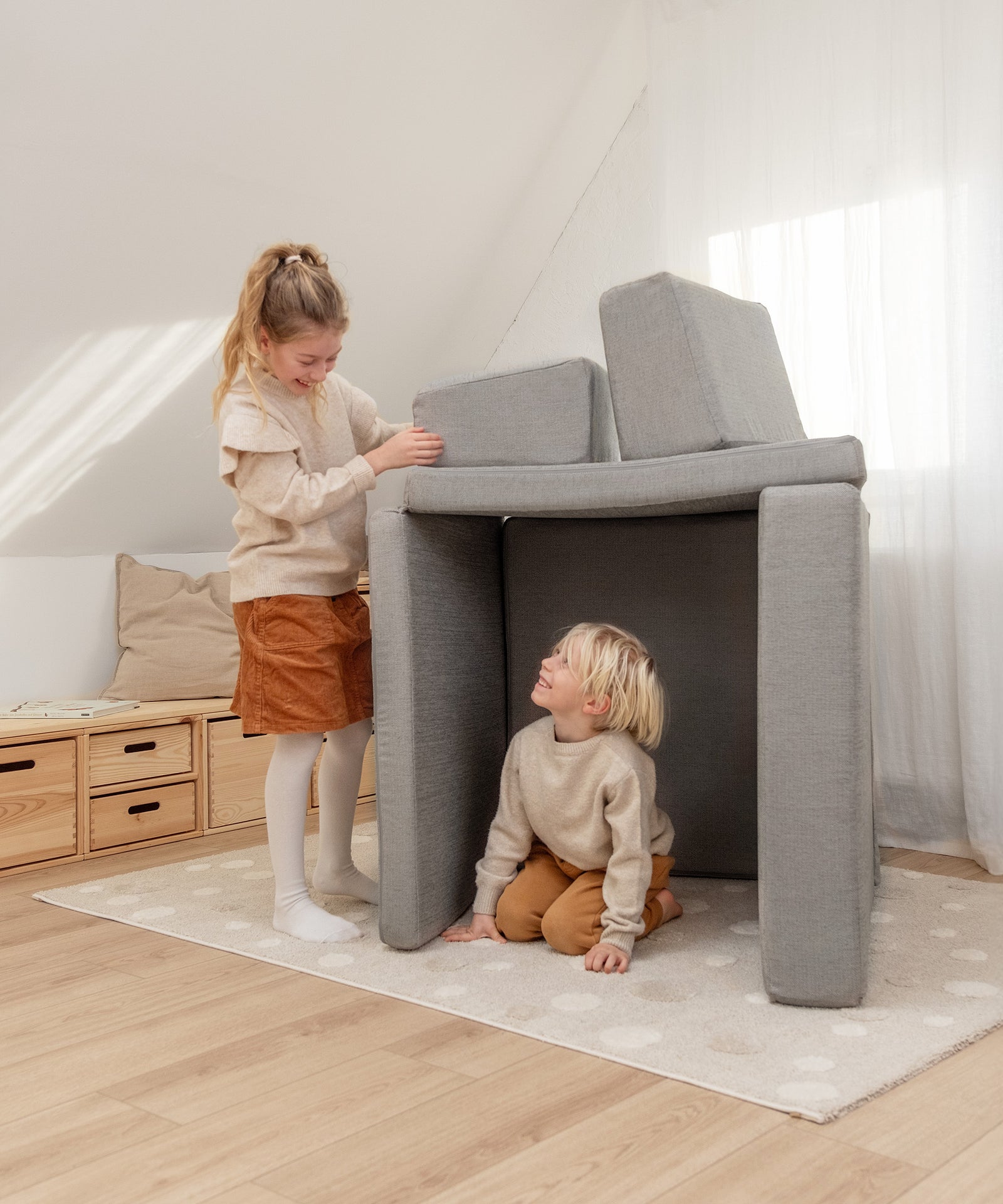 Kinder bauen eine Höhle aus dem Spielsofa.