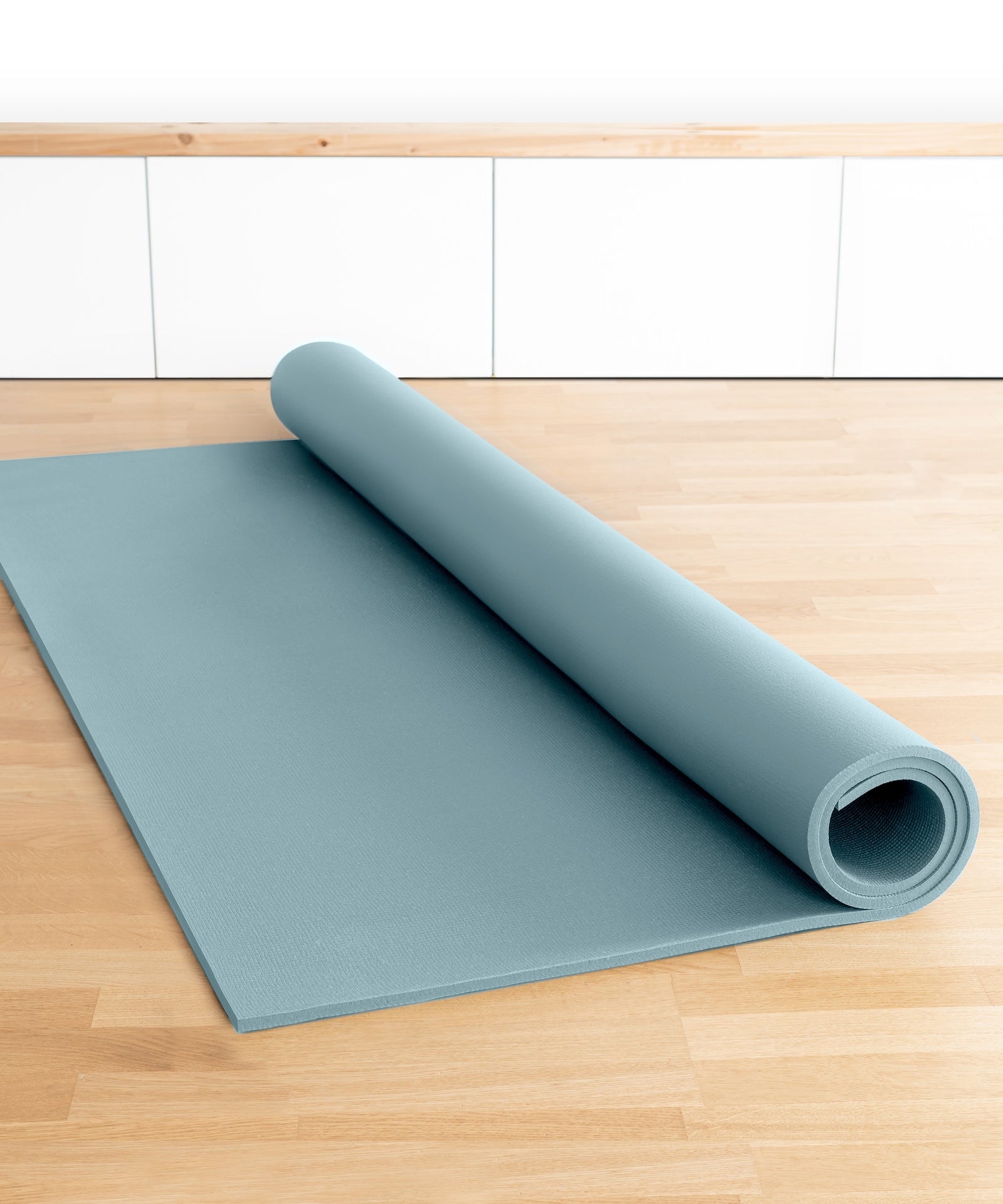 Praktisch rollbar|Krabbelmatte PRO liegt eingerollt auf dem Boden.