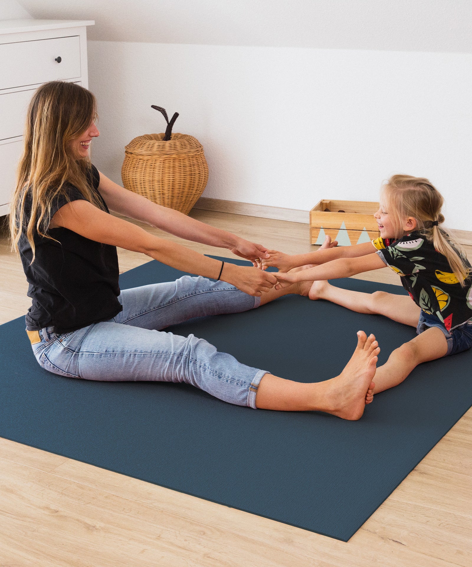 Frau und Kind toben auf Krabbelmatte Blau.