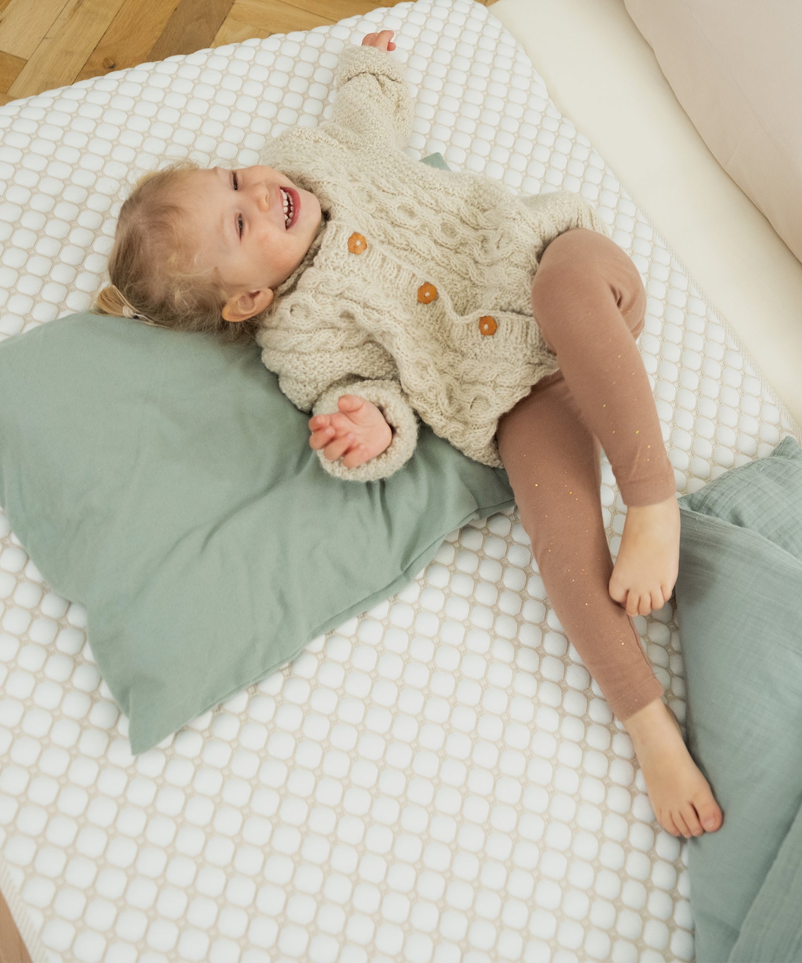 Erfrischend & atmungsaktiv*Die Matratzenauflage reguliert Wärme und Feuchtigkeit. Kühlfasern sorgen für ein trockenes und angenehmes Schlafklima.|Kind liegt auf kühlender Matratzenauflage.