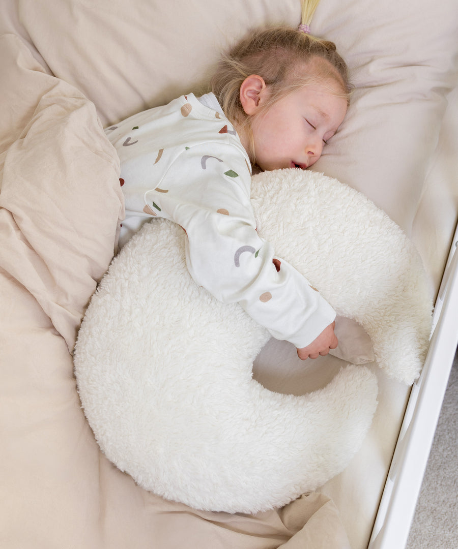 Pflegeleichtes Kuschelkissen in Mondform aus weichem Teddystoff.