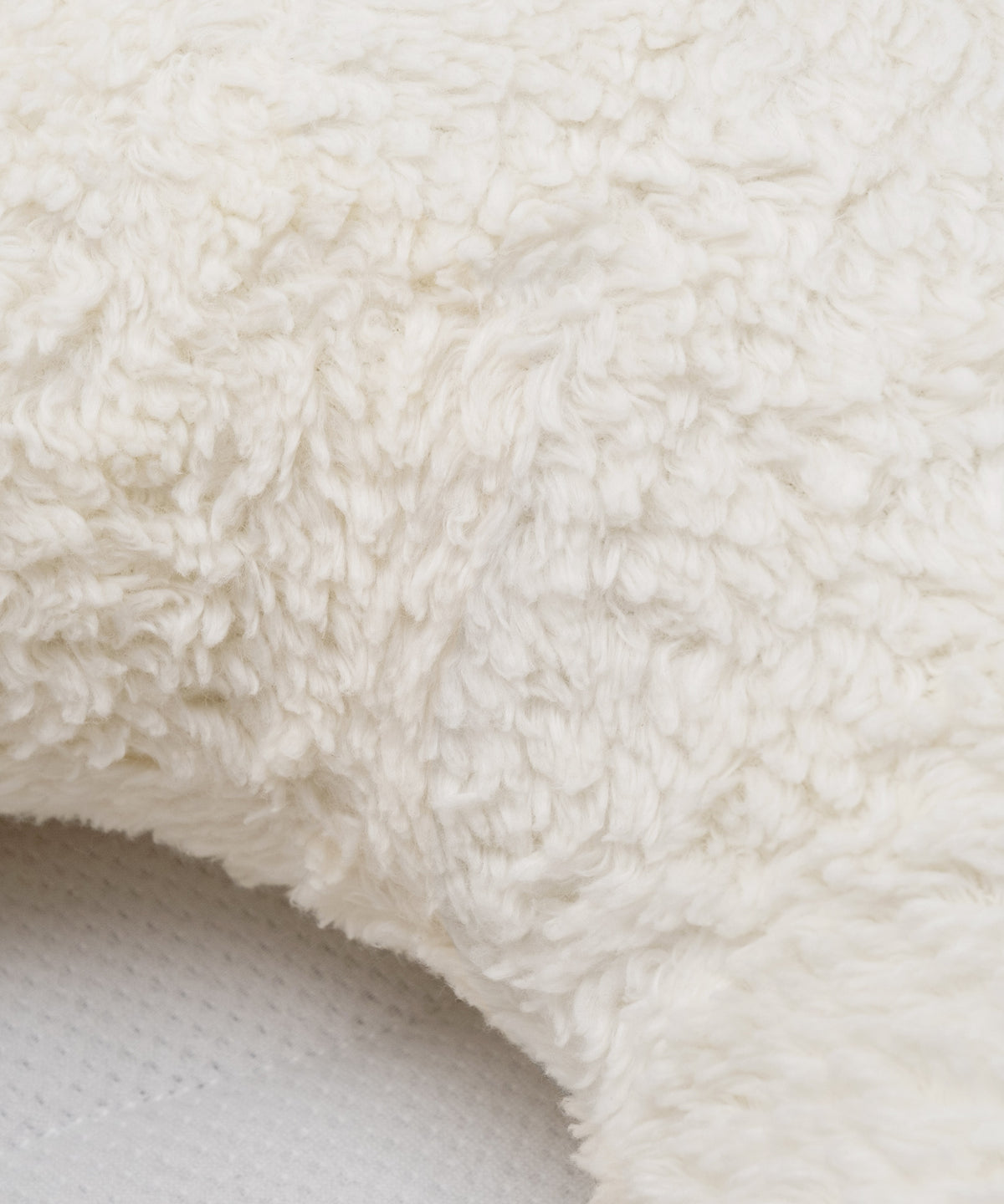 Pflegeleicht im Alltag*Das Kuschelkissen hat keinen störenden Reißverschluss und kann bei 30°C komplett in der Waschmaschine gewaschen werden.| Nahaufnahme des Kuschelkissens mit Teddystoff.