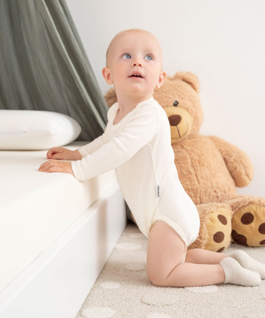 Baby in Langarmbody Merinowolle Natur.