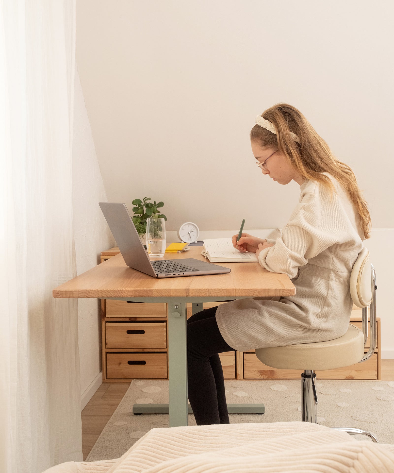 Kind sitzt am Schreibtisch und lernt.