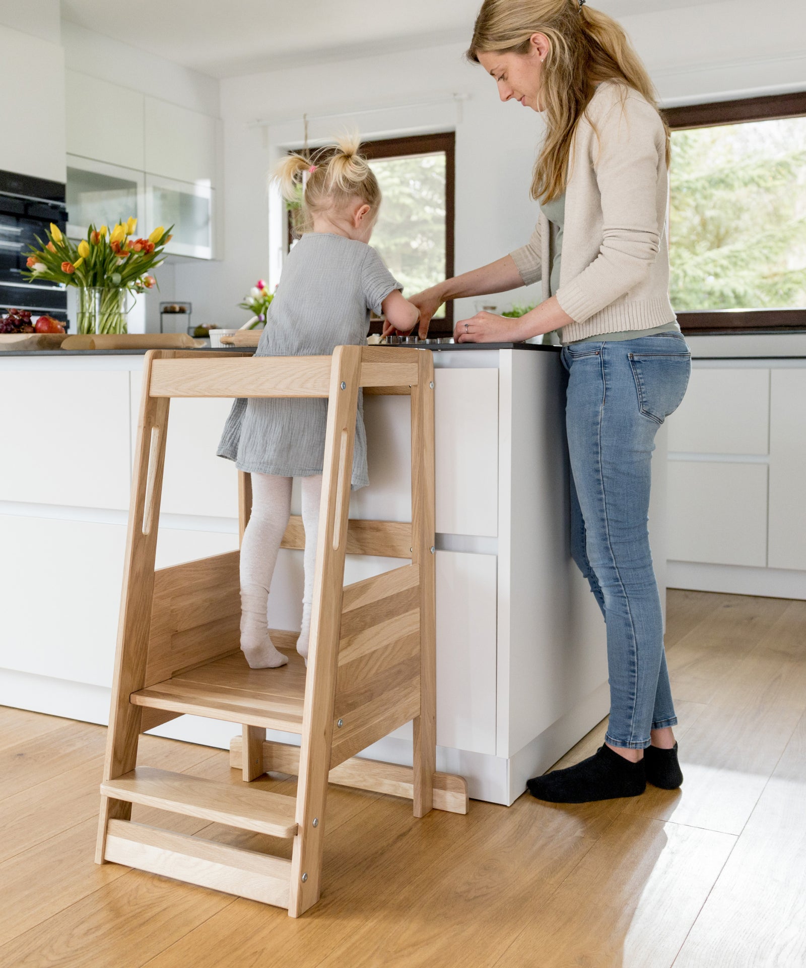 Montessori Lernturm aus Eiche in der Küche im Familienalltag