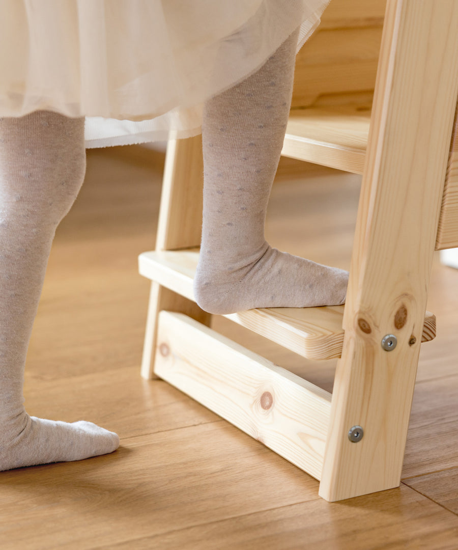 Lernturm mit Kleinkindstufe für kleine Kinder beim sicheren Einstieg.