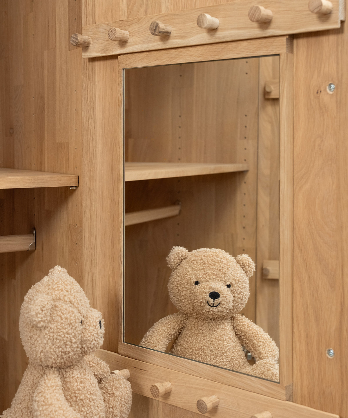 Die Türinnenseite mit Hakenleisten und Spiegel unterstützt Kinder beim selbstständigen Anziehen.