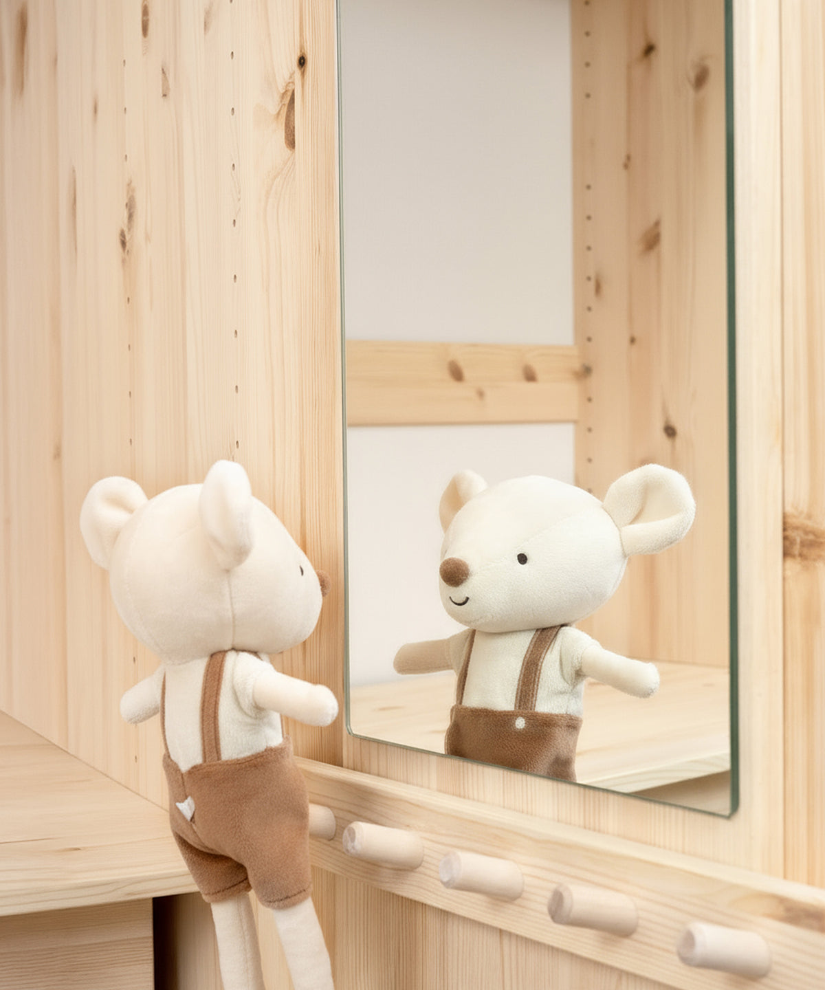 Die Türinnenseite mit Hakenleisten und Spiegel unterstützt Kinder beim selbstständigen Anziehen.