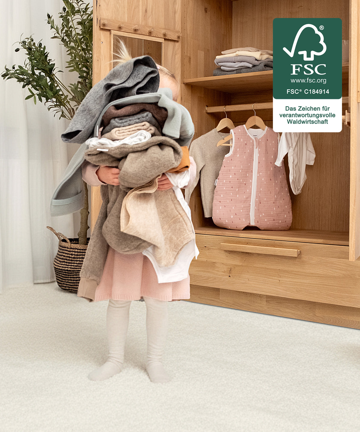 Für kleine Hände gemacht*Die kindgerechte Höhe ermöglicht selbstständiges Anziehen und Aufräumen - unterstützt spielerisch die Entwicklung im Alltag.| Mädchen trägt selbstständig die Kleidung in den Kleiderschrank.