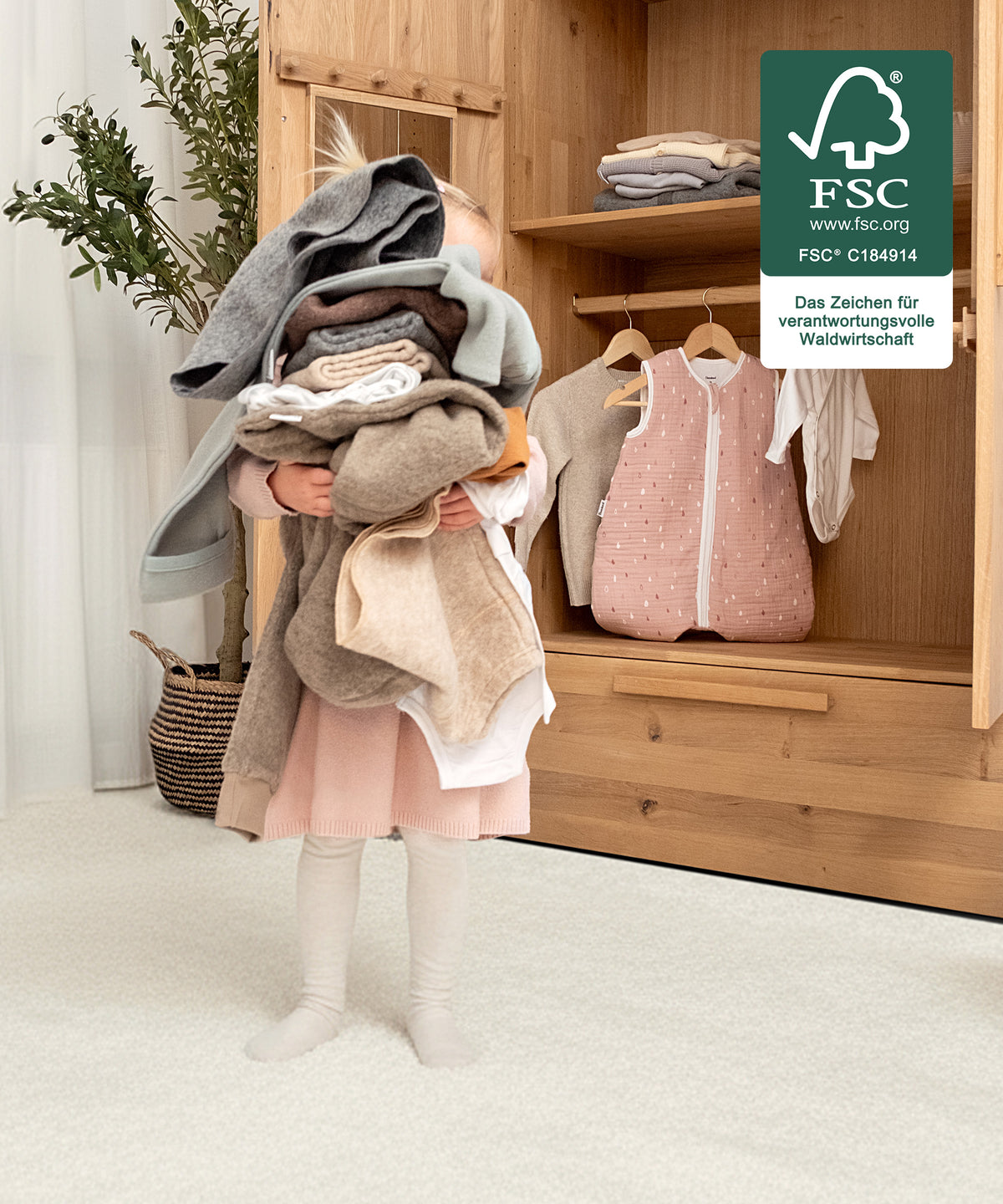 Für kleine Hände gemacht*Die kindgerechte Höhe ermöglicht selbstständiges Anziehen und Aufräumen - unterstützt spielerisch die Entwicklung im Alltag.| Mädchen trägt selbstständig die Kleidung in den Kleiderschrank.