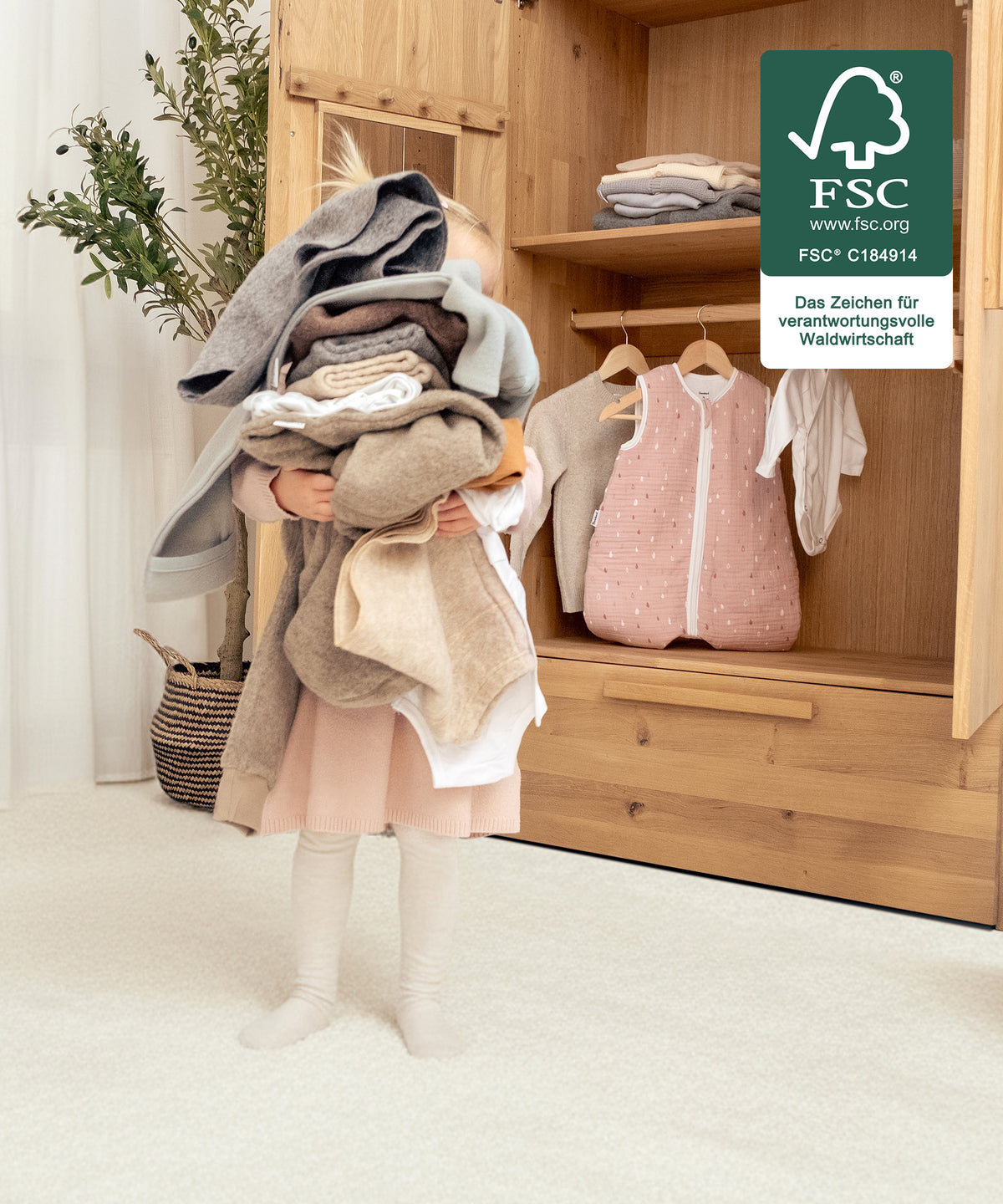 Für kleine Hände gemacht*Die Innenaufteilung lässt sich so gestalten, dass Kinder Kleidung selbst erreichen - unterstützt spielerisch Selbstständigkeit.| Mädchen trägt selbstständig die Kleidung aus dem Kleiderschrank.