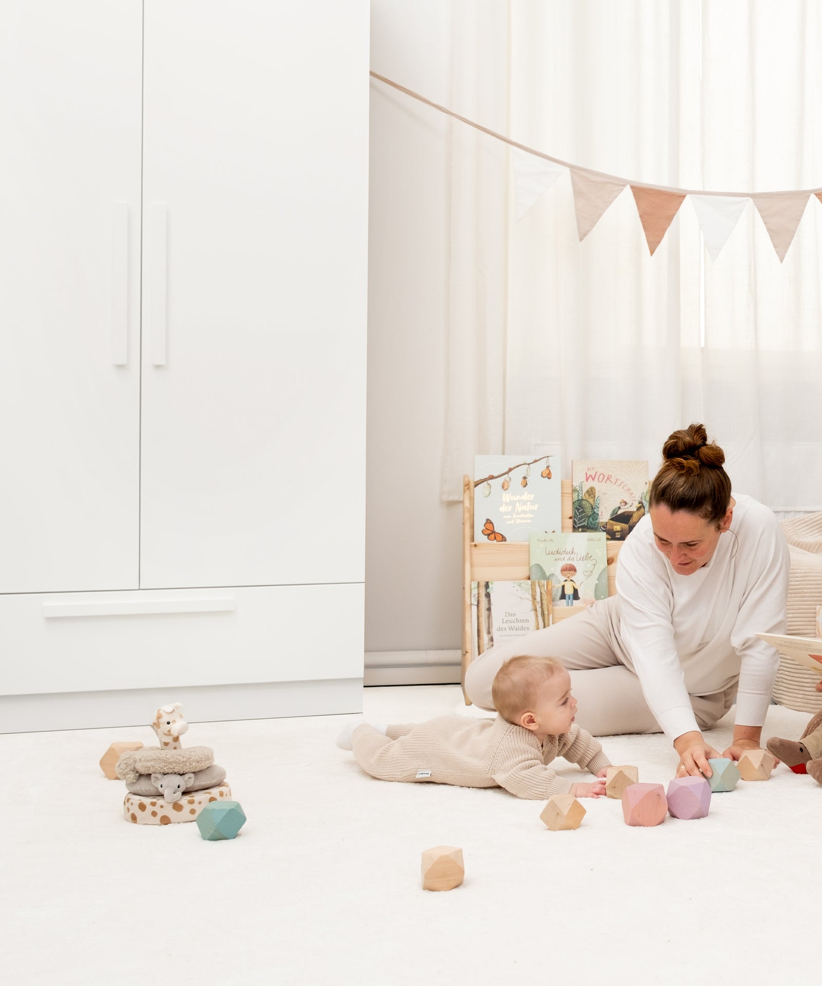 Familienmoment mit spielendem Kind vor dem weißen Linia Schrank.