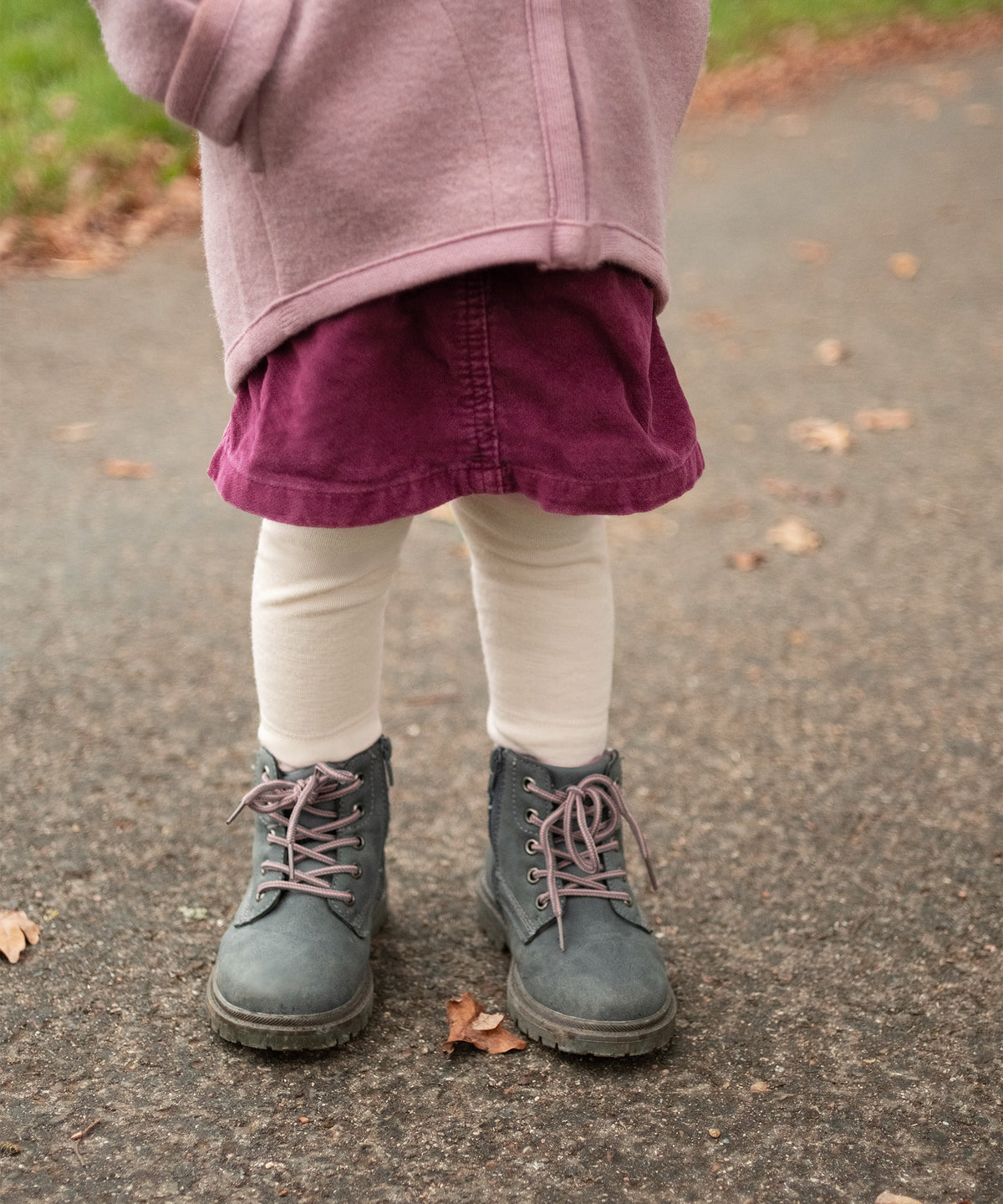 Kind in Merino Leggings natur in Kombination mit Rock.