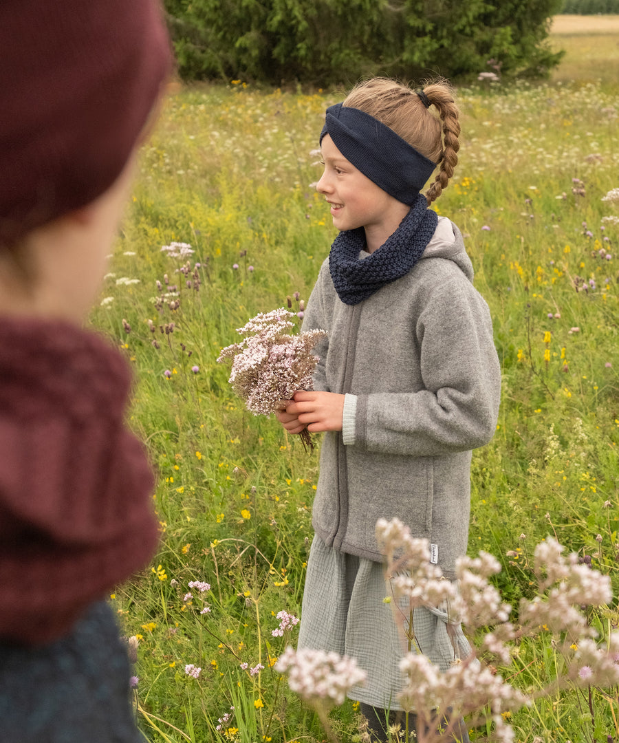 Praktisches Set*Das Knotenstirnband ist perfekt kombinierbar mit unseren Schlauchschals - stilvoll, funktional und immer passend.| Mädchen trägt den passenden Schlauchschal zu dem Stirnband in der Farbe Dunkelblau.