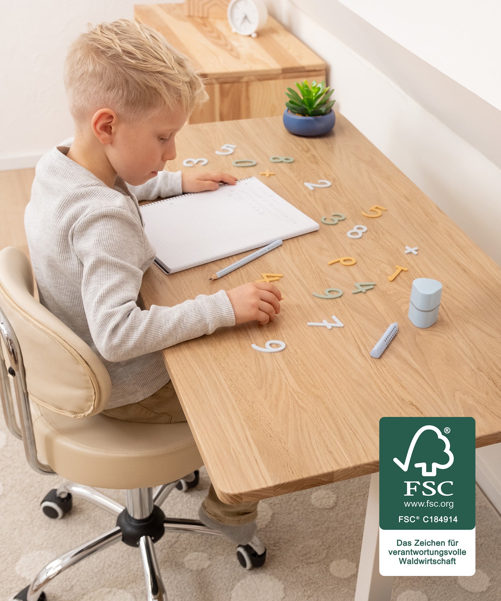 Mitwachsend & ergonomisch*Stufenweise höhenverstellbar: der Schreibtisch wächst dank einfacher Verstellung in 5-cm-Schritten (55-85 cm) mit.| Kind lernt am Schreibtisch mit viel Arbeitsfläche.