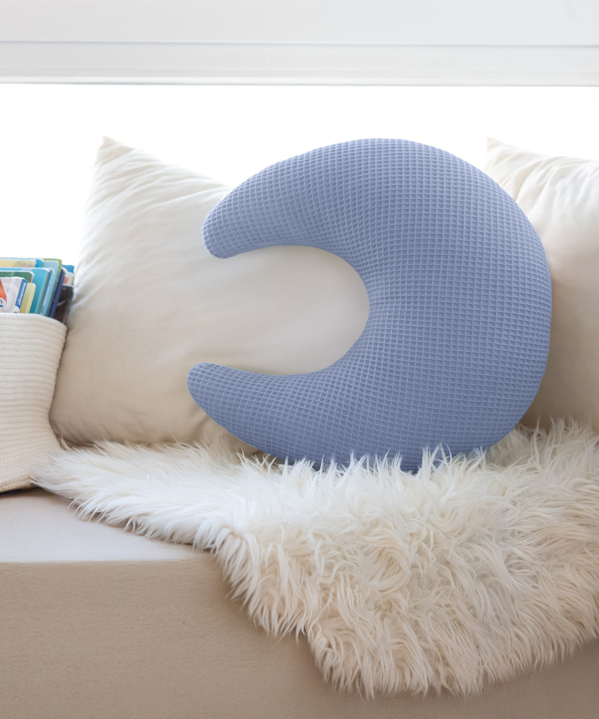 Mondförmiges Kuschelkissen aus Waffelpiqué auf Sofa.