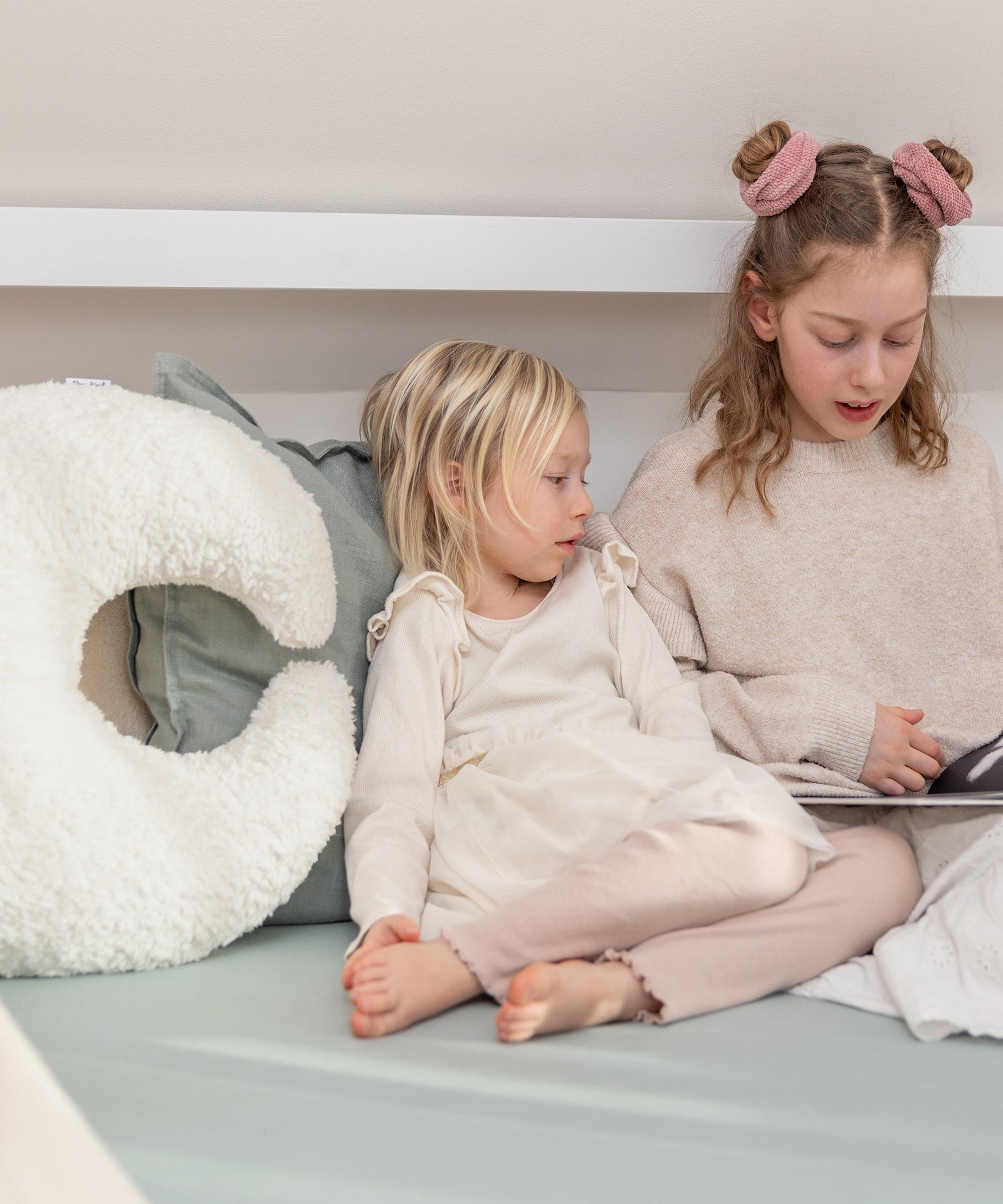 Mondförmiges Kuschelkissen aus Teddystoff beim Lesen und Kuscheln