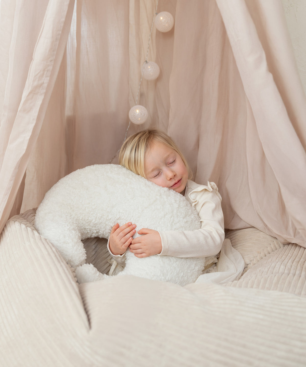 Mondförmiges Kuschelkissen aus Teddystoff.