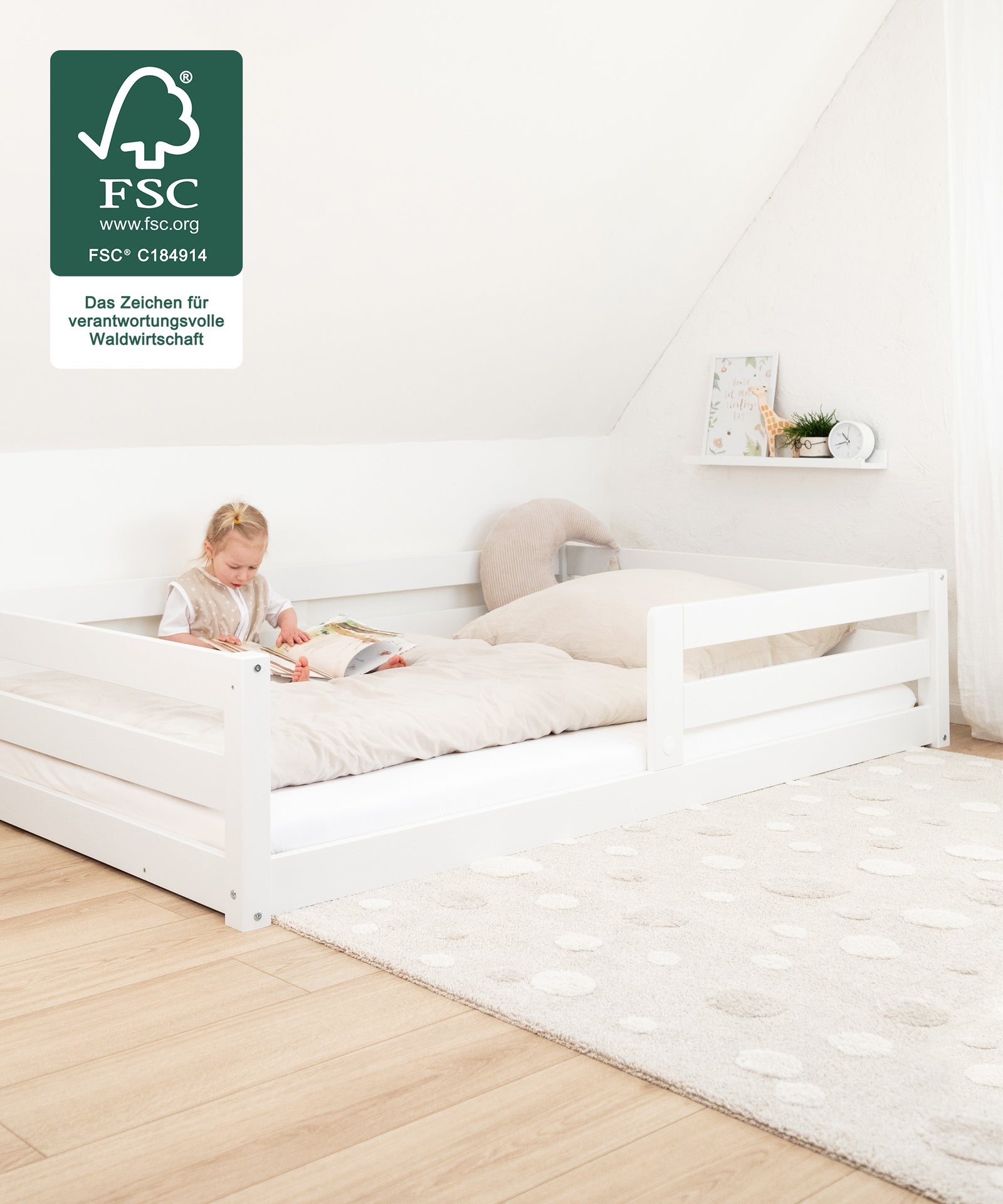 2 Farben & 2 Größen*
Das Bett ist in Natur und Weiß in den Größen 90 x 200 cm und 120 × 200 cm erhältlich - genug Platz zum gemeinsamen Kuscheln!|Kind liest ein Buch im Bodenbett Sona im Kinderzimmer.