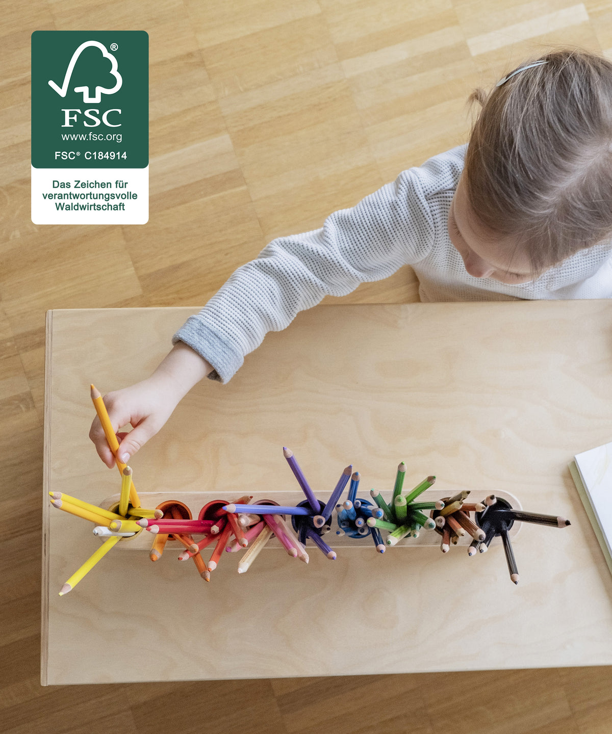 Kinder sortiert Stift in Stiftehalter ein.