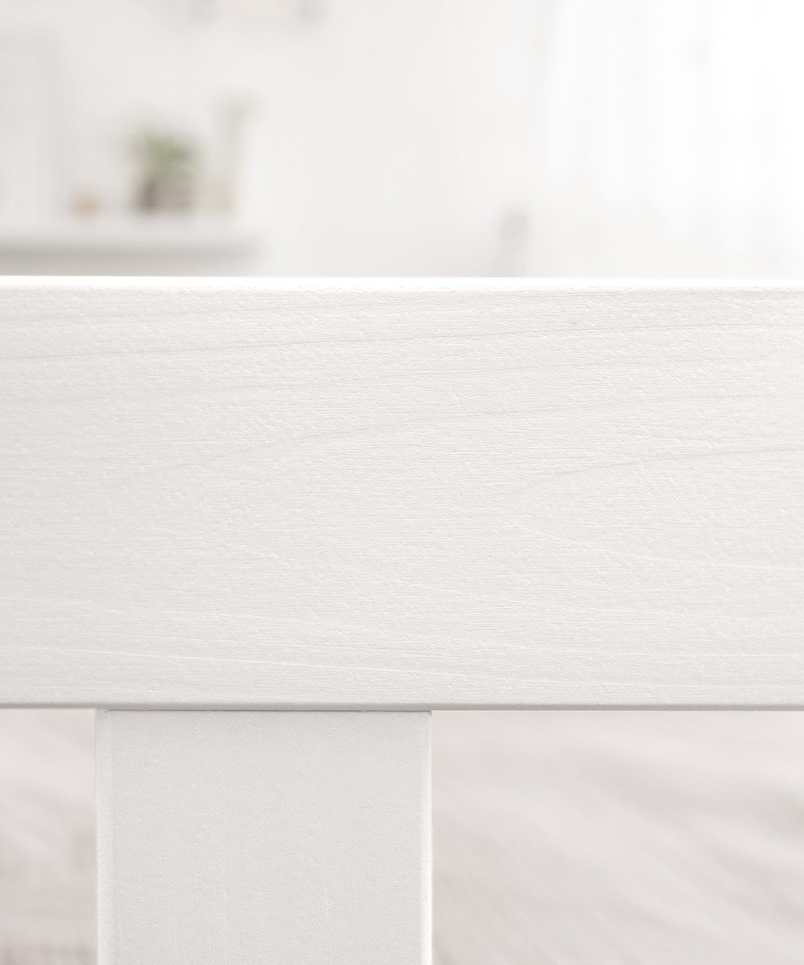 Nahaufnahme weiß lackiertes Holz vom Montessori Bodenbett Kiefer weiß.