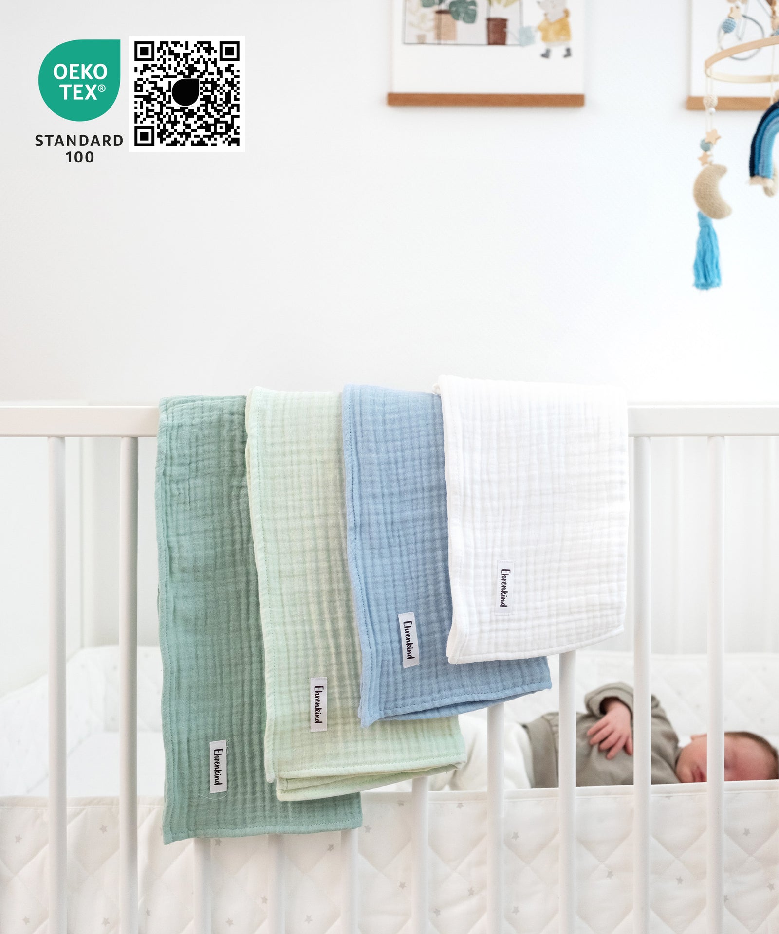 Mulltücher-Set Blau hängt über Gitterbett.