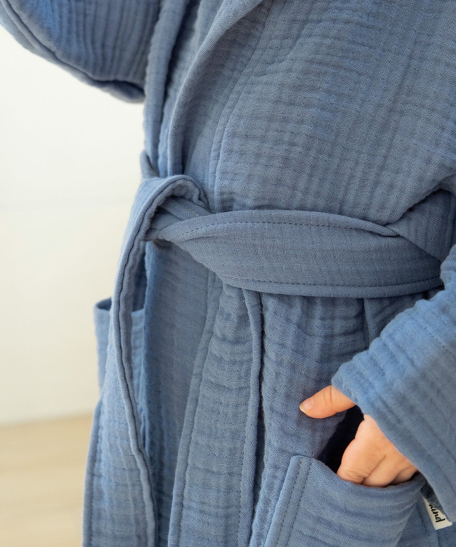 Komfortabel & praktisch*Weicher Musselin trifft durchdachtes Design: Der Bindegürtel sorgt für sicheren Sitz, ohne einzuengen.|Nahaufnahme Bindegürtel am Musselin Bademantel.