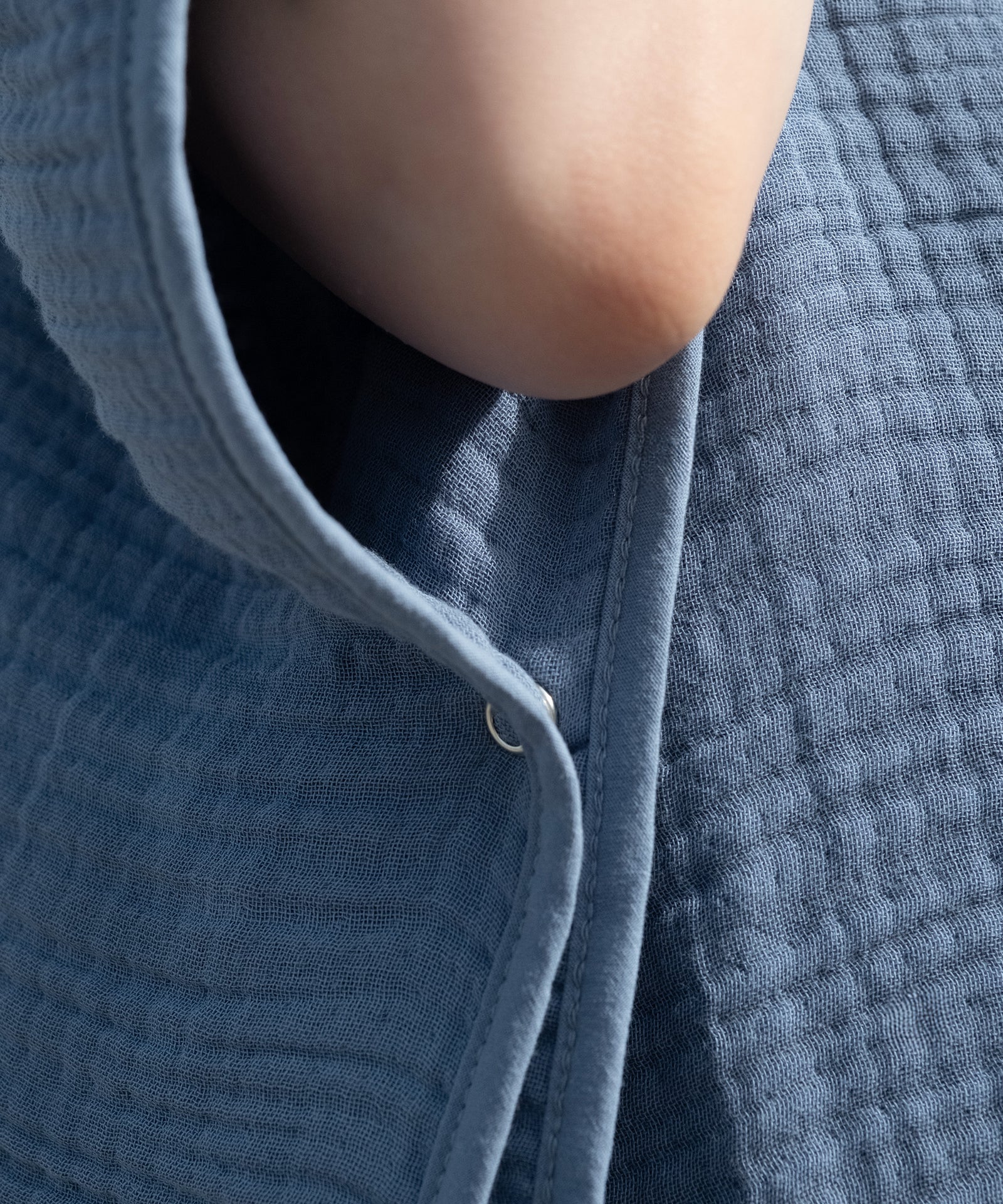 Sicherer Sitz mit Knopf*Ein seitlicher Druckknopf hält den Poncho sicher in Position. So bleibt dein Kind eingehüllt und kann sich trotzdem frei bewegen.|Druckknopf Detail Musselin Badeponcho.