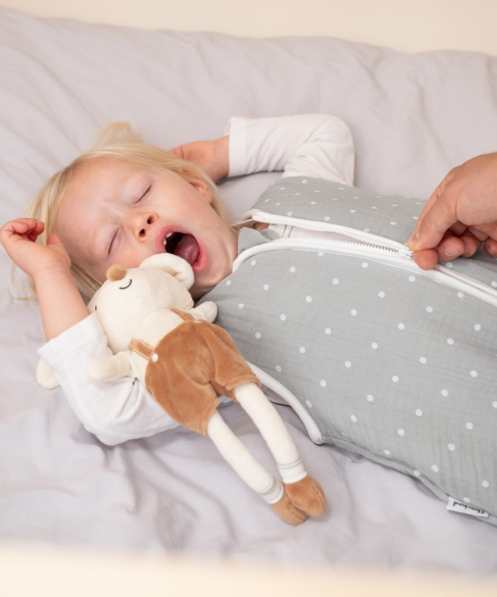 Schutz-Reißverschluss*Der Reißverschluss lässt sich leise öffnen und ist mit einer Schutzabdeckung versehen, die das Kinn am Verschlussende schützt.|Kind in Schlafsack mit Sicherheits-Reißverschluss.