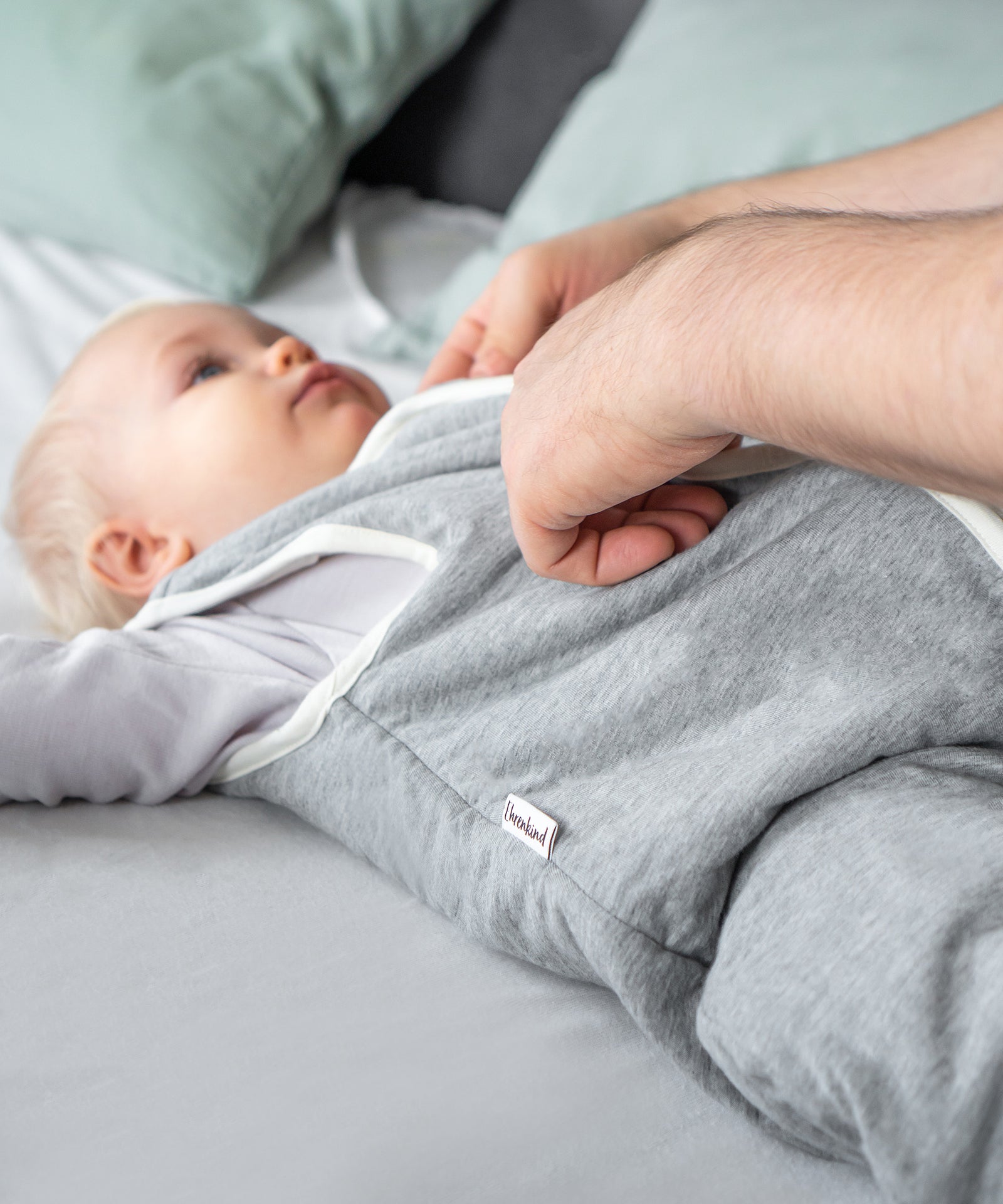 Weich wattiert*Der Ganzjahresschlafsack mit TOG 2.0 ist mit einer leichten, wärmenden Wollwattierung ausgestattet.| Kind trägt Schlafsack grau.