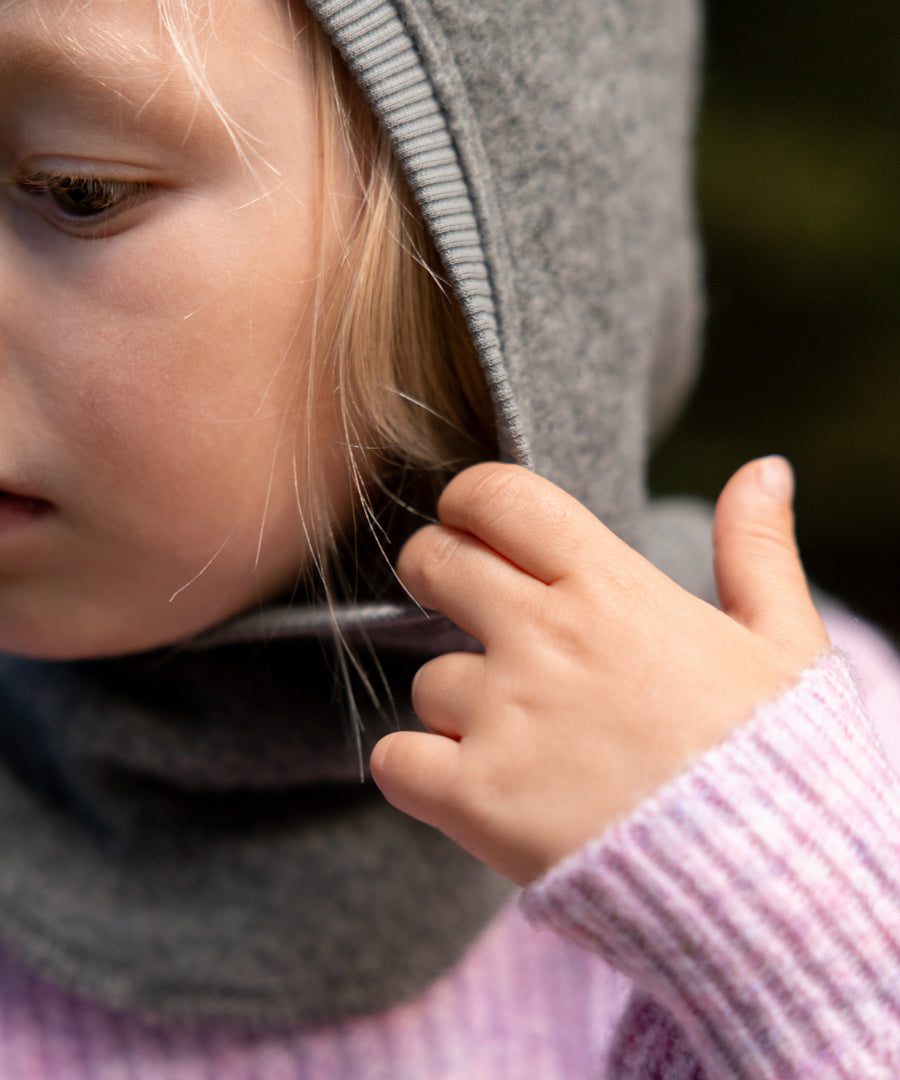 Für aktive Kleinkinder*Dank des dehnbaren Rippbündchens um das Gesicht hat die Mütze einen guten Sitz und lässt sich bequem an- und ausziehen.|Kind trägt die Schlupfmütze in Grau.