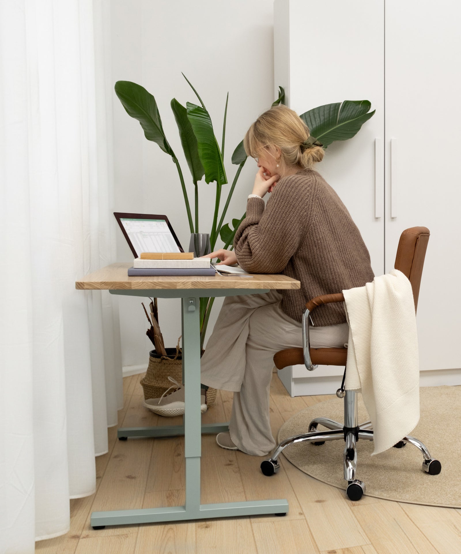 Frau sitzt am Schreibtisch und arbeitet.