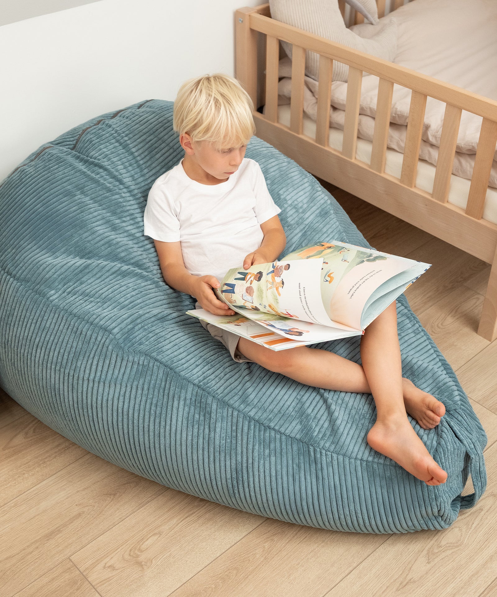 Kind sitzt im Sitzsack und liest ein Buch.