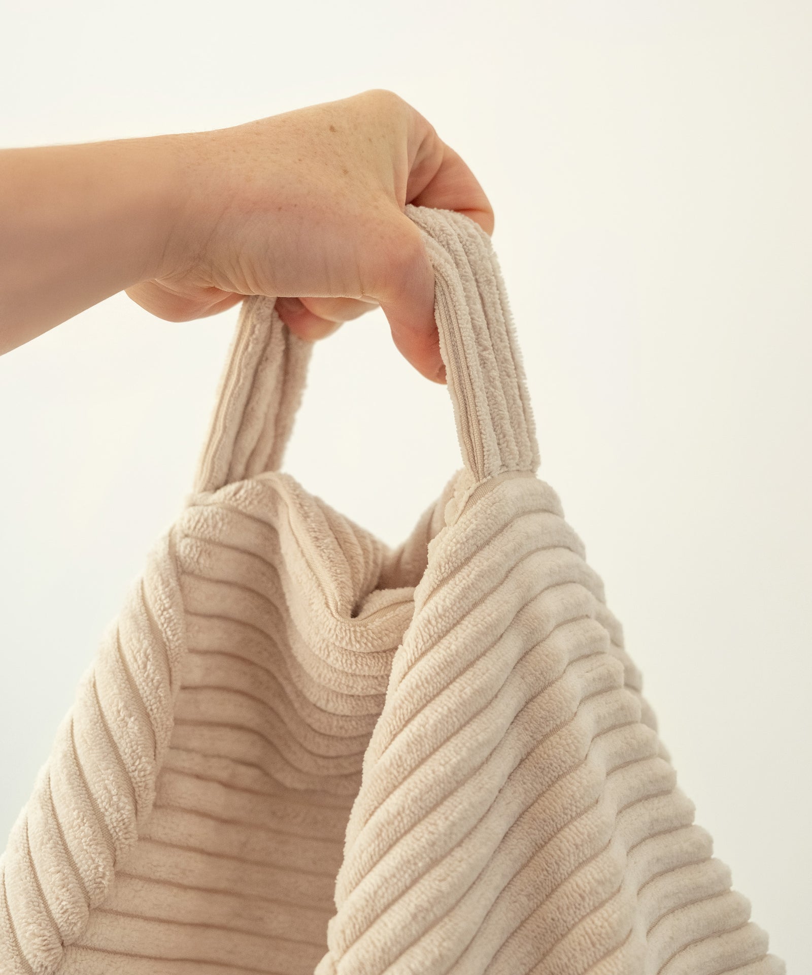 Einfach transportieren*Dank praktischem Griff lässt sich der Sitzsack mühelos von Raum zu Raum tragen – für flexible Nutzung im Alltag.|Sitzsack wird am Tragegriff gehalten.