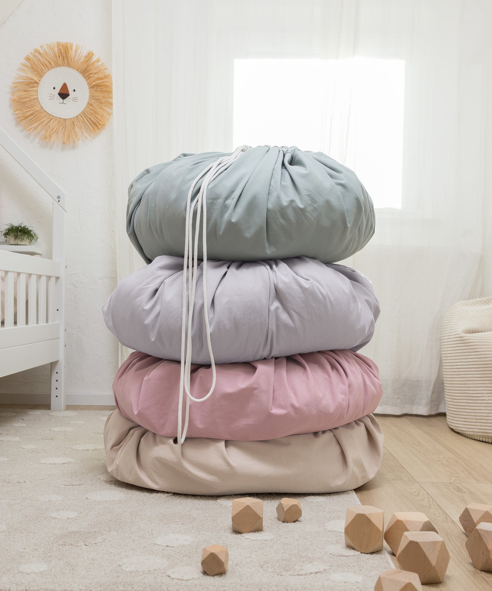 Großer runder Aufräumsack für Kinder in den Farben Jade, Hellgrau, Rosé und Beige.
