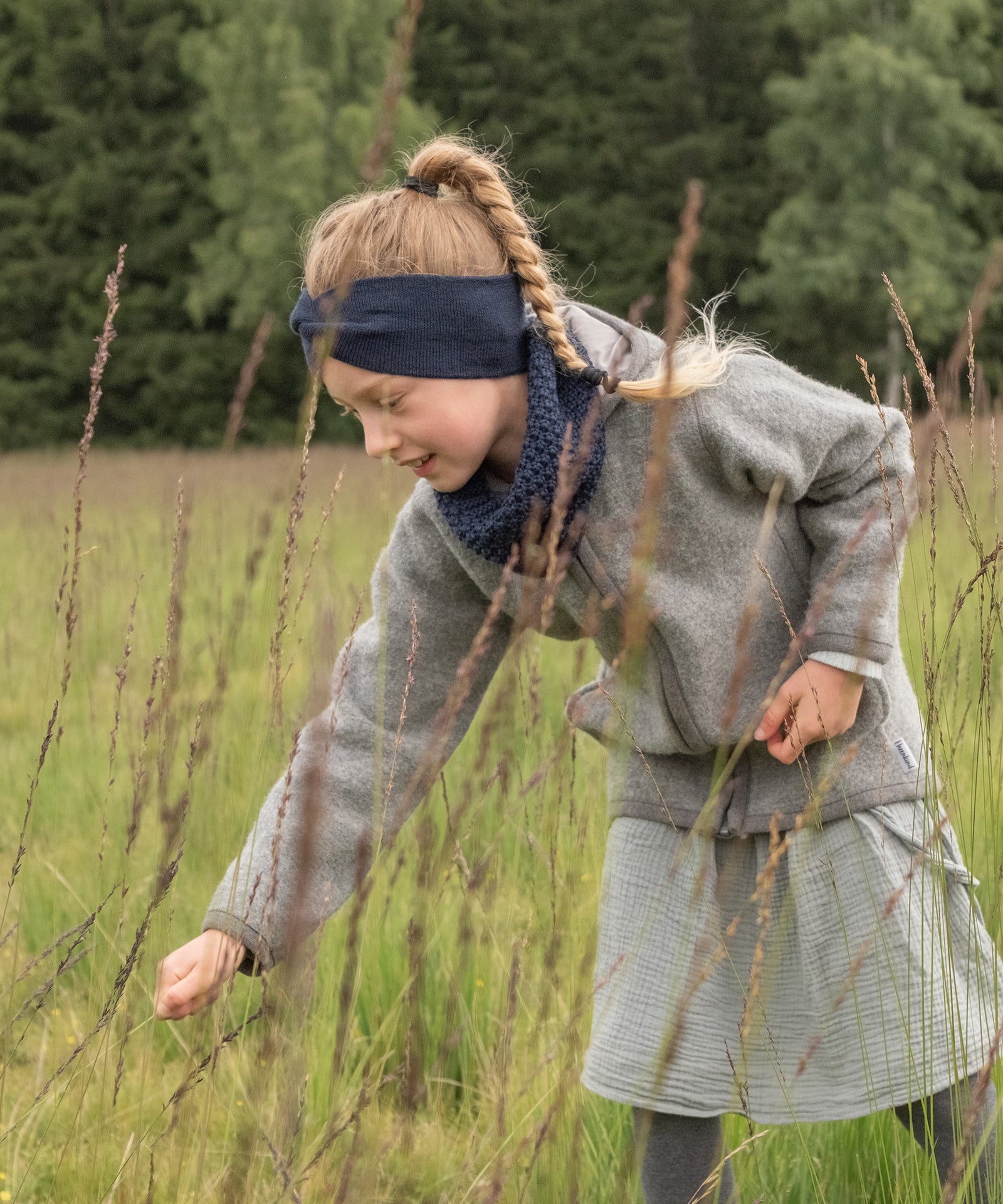 Knotenstirnband kombiniert mit Schlauchschal, Kind spielt im Garten
