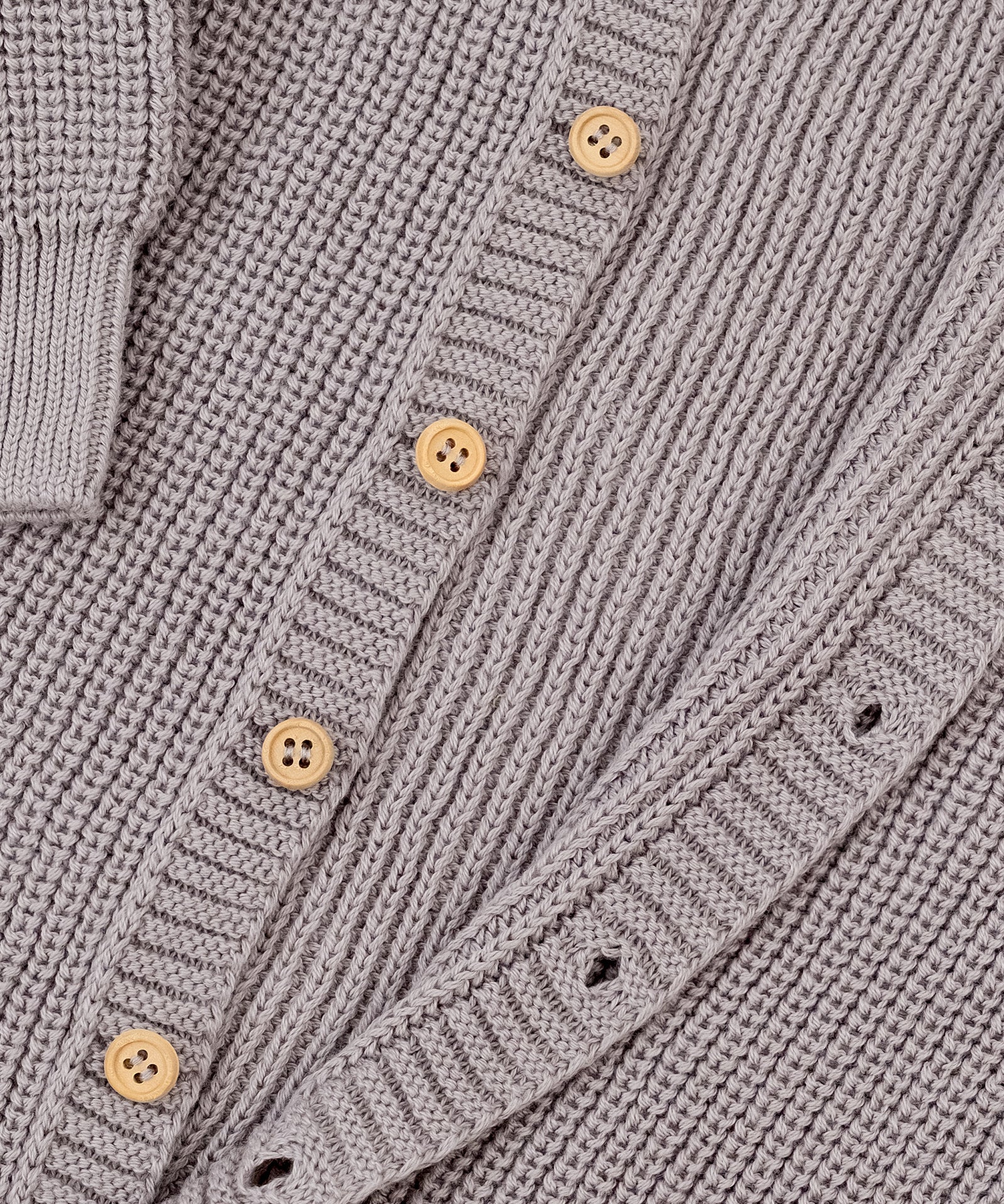 Ohne störende Nähte*Raglanärmel, durchgehende Knopfleiste und elastische Bündchen erleichtern das Anziehen und sorgen für einen perfekten Sitz.| Nahaufnahme Strickoverall Knopfleiste.