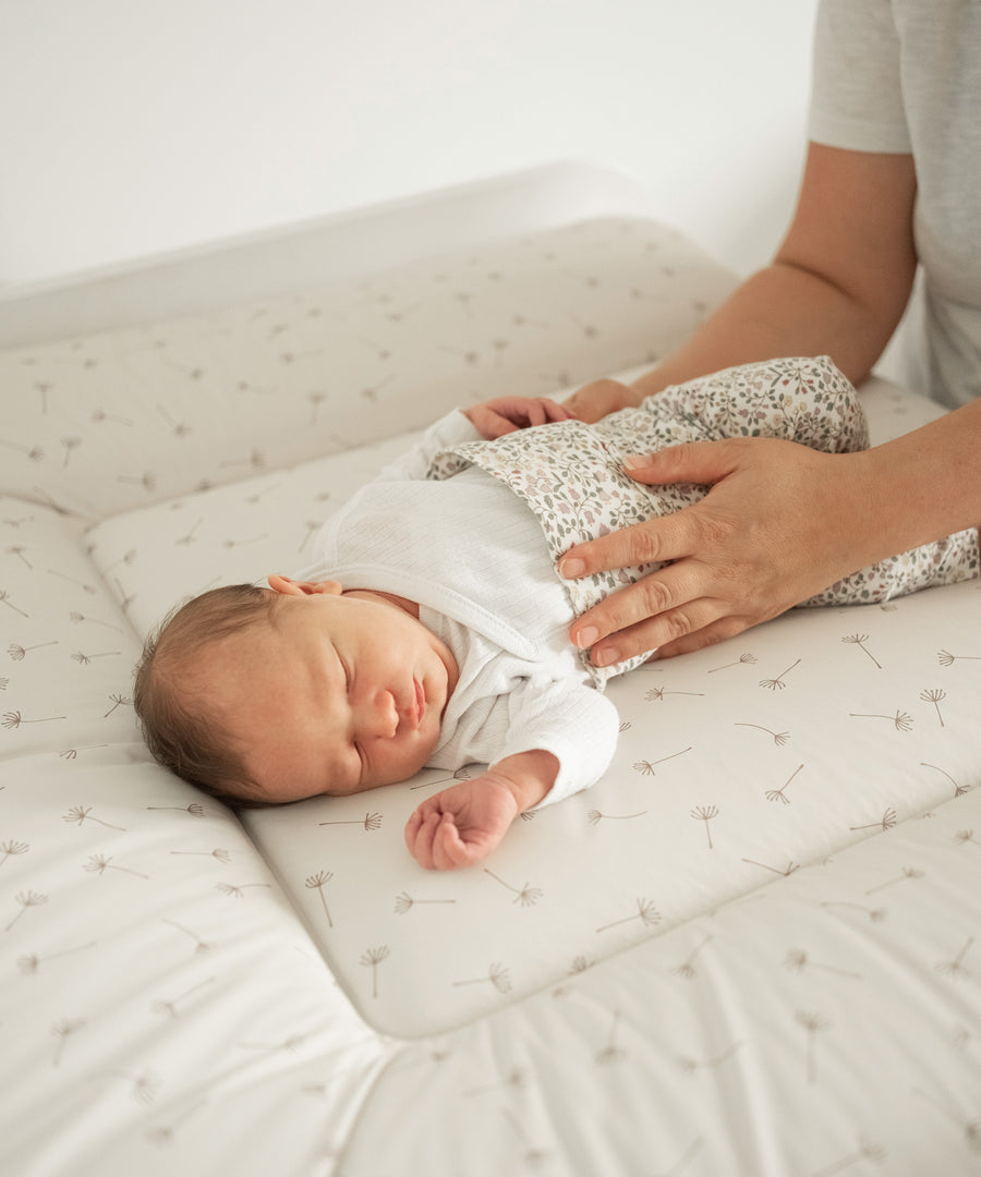 Für mehr Komfort*Die leicht erhöhten, weichen Seitenränder lassen sich flexibel hochklappen und bieten einen angenehmen Komfort für dein Baby.|Baby liegt auf Wickelauflage abwaschbar 72x85 cm.