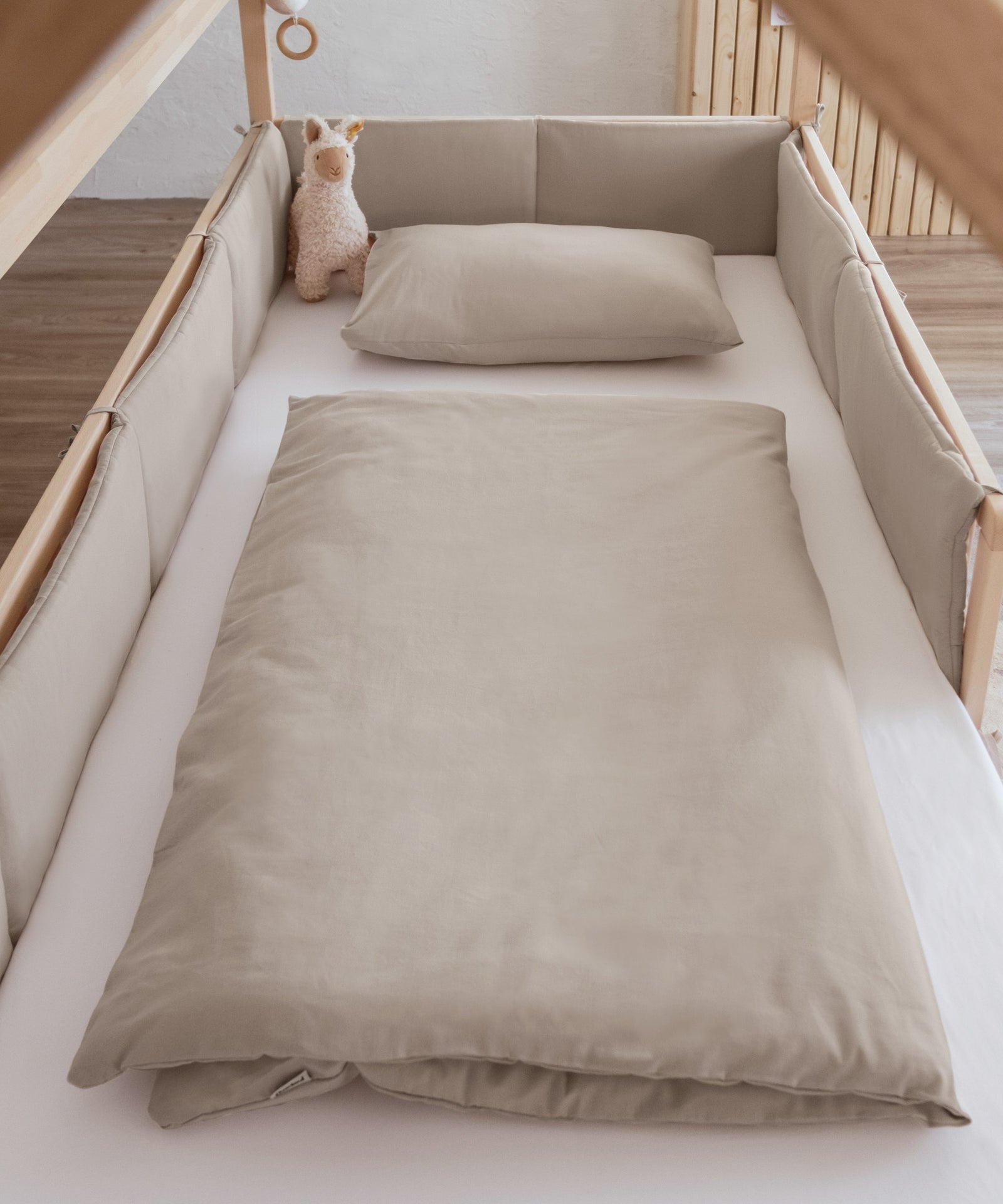 Bettumrandung und Bettwäsche in beige.